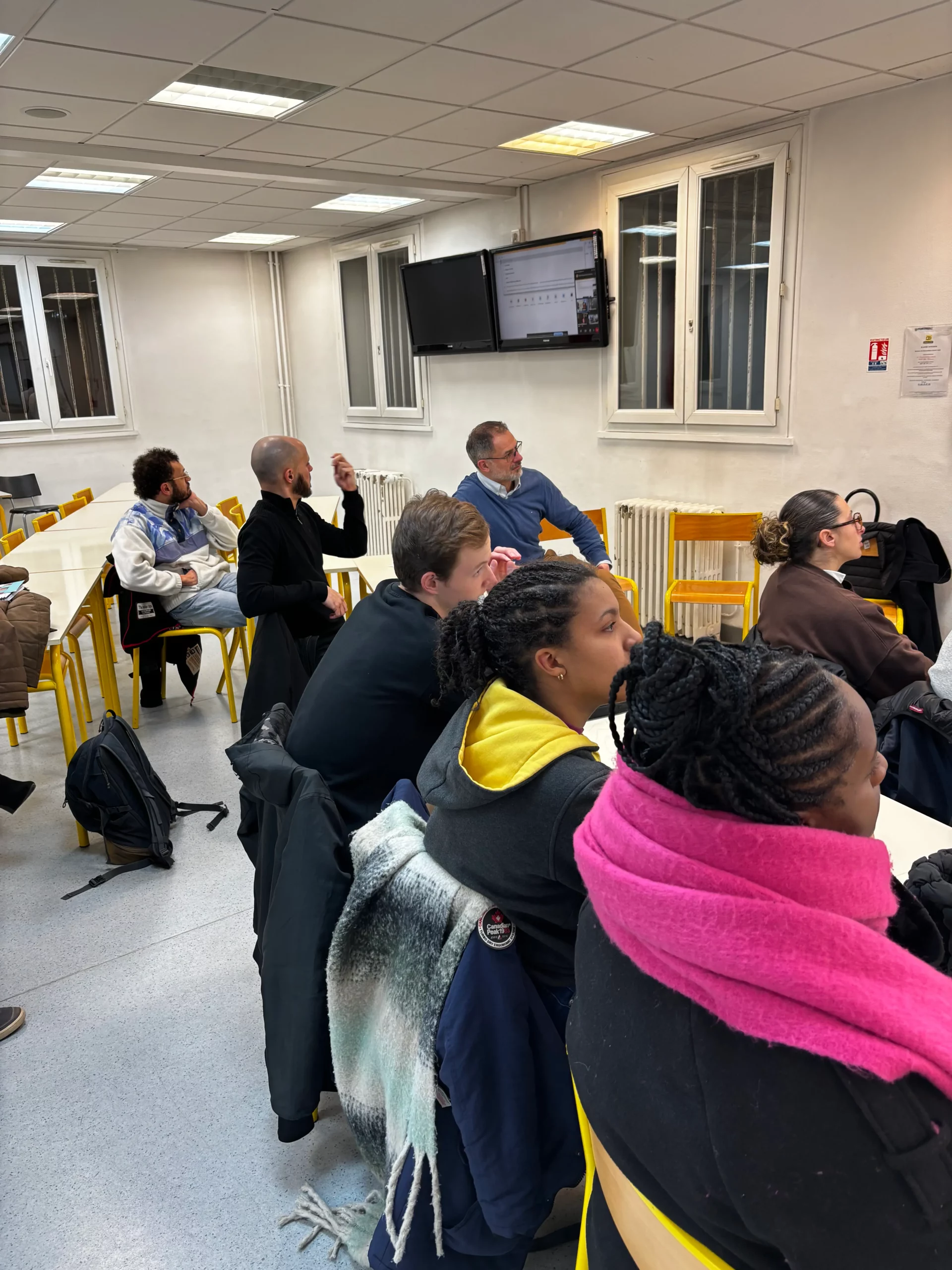 Les professeurs et étudiants écoutant la présentation des formations continues