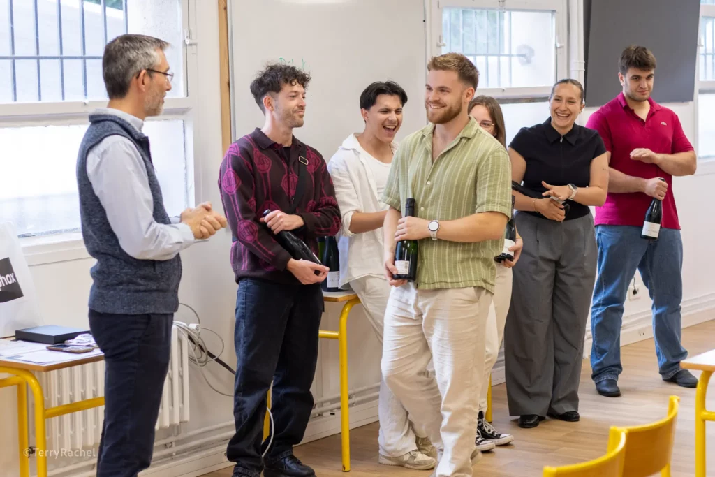 étudiant Ostéobio souriant recevant une bouteille de champagne et étant applaudi par ses camarades de promotion
